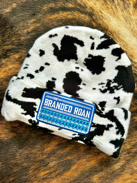 The Branded Roan - Black & White Cowprint Toque W/ Blue Aztec Patch