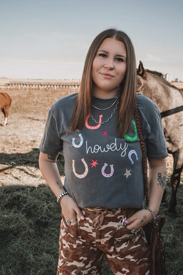 Close-up of charcoal Comfort Colors graphic tee featuring a colourful DTF printed horseshoe and Howdy design.